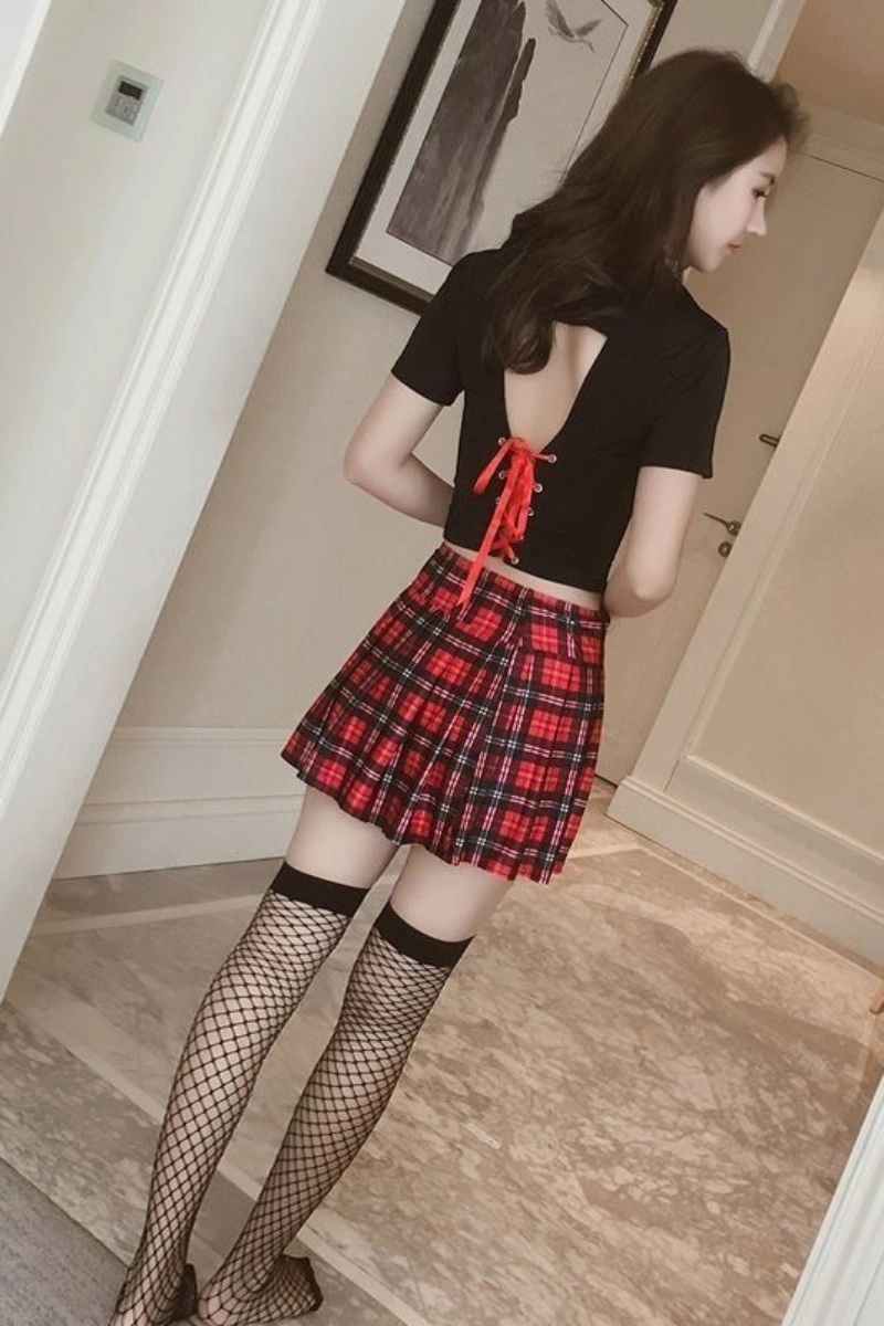 Back view of black JK cosplay costume with lace-up red ribbon design on the black top and red plaid pleated skirt.