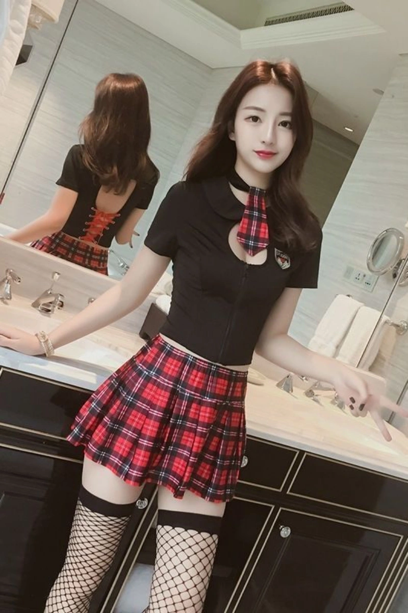 Model wearing black JK cosplay costume featuring a fitted black top with cutout design and red plaid pleated mini skirt.