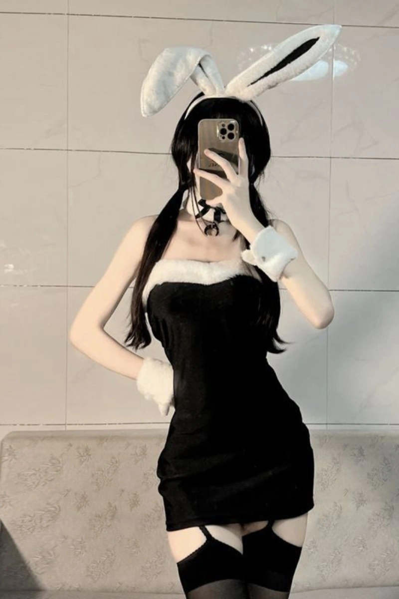 Model in a black bunny lingerie bodysuit with white fur details and bunny ears