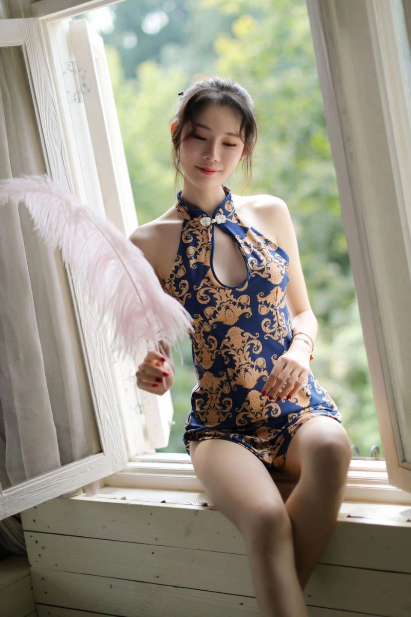 Sexy cheongsam lingerie in navy blue with golden ornate pattern, model sitting by the window