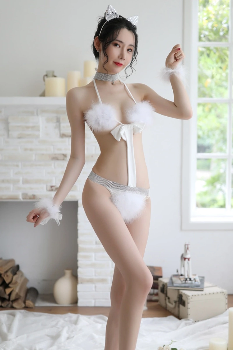 Model dressed in white cat lingerie for women featuring fluffy trim, a satin bow, and cat ear headband.