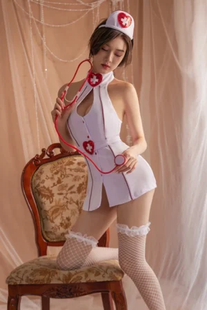 Model wearing a white nurse uniform bodysuit styled with red heart cross details, nurse hat, and stethoscope prop