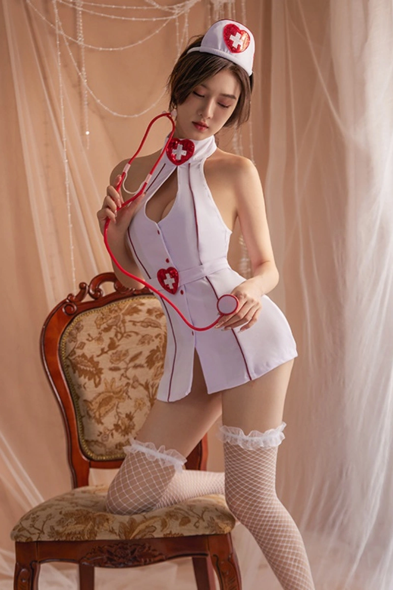 Model wearing a white nurse uniform bodysuit styled with red heart cross details, nurse hat, and stethoscope prop