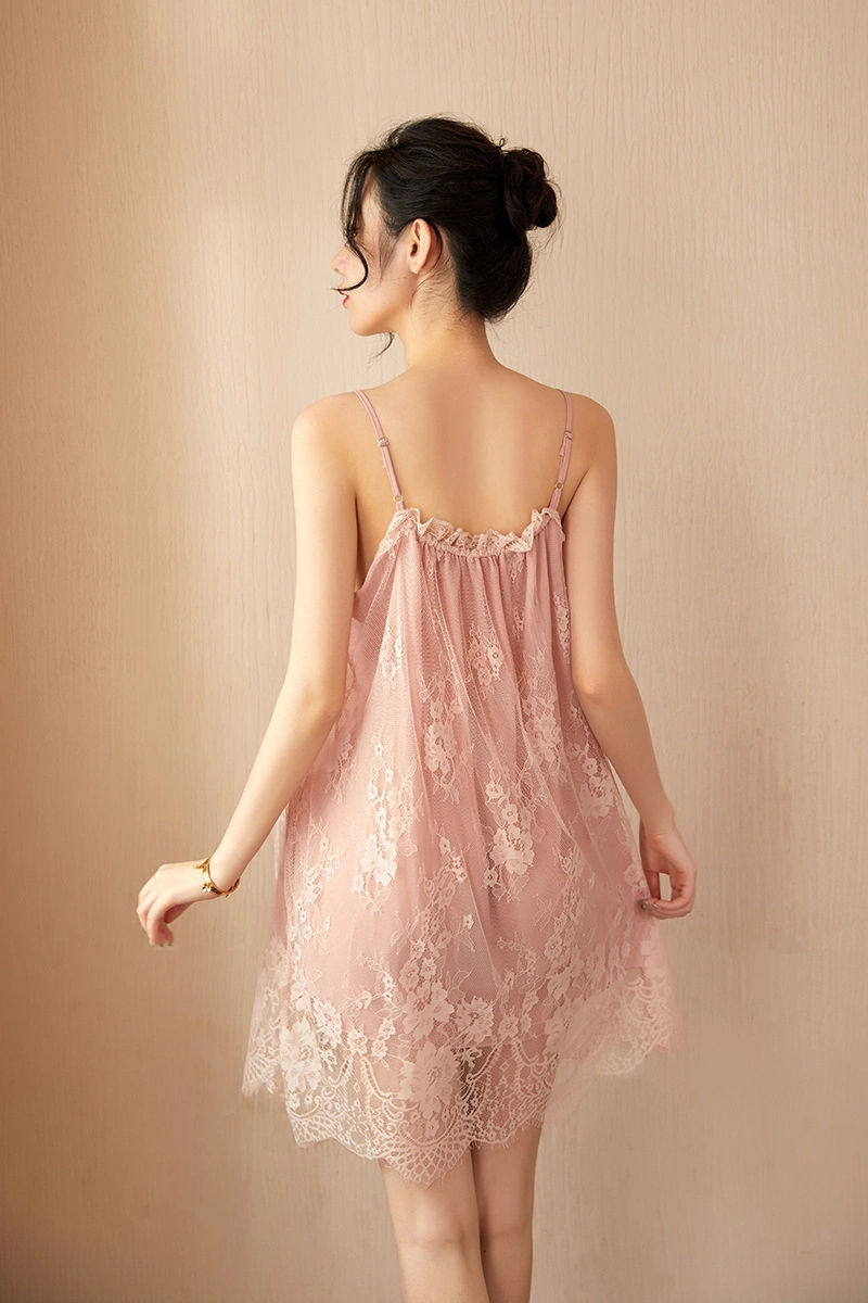 Model wearing pink pajamas with lace, showcasing a delicate floral lace hem and backless flowy style.