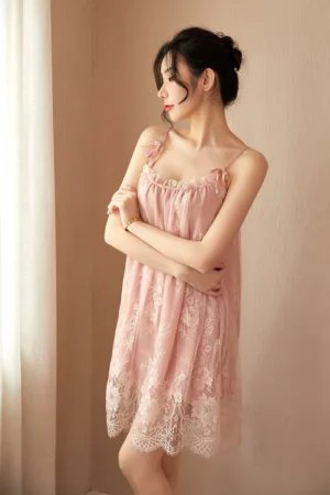 Soft pink pajamas with lace, styled with floral lace hem and bow accents.