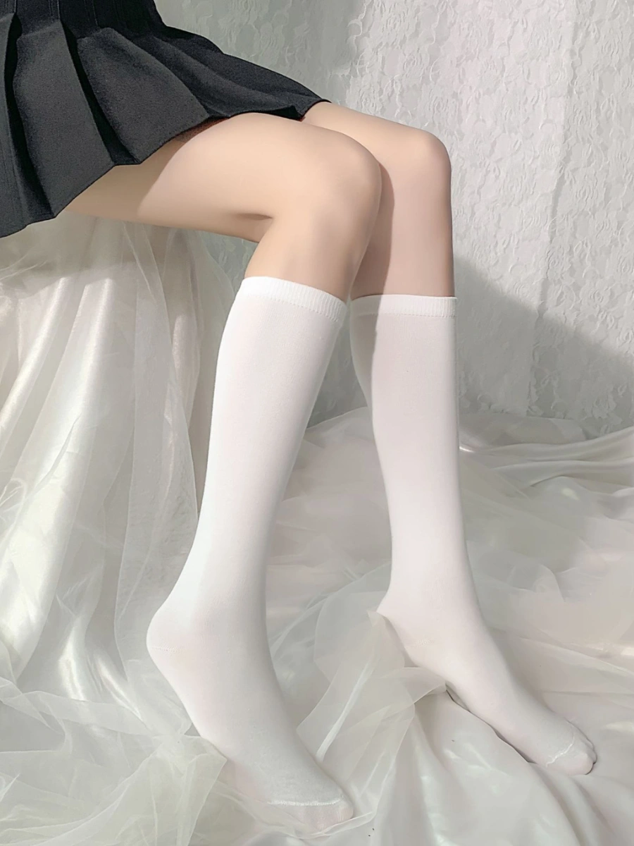 Model wearing silk stockings in black thigh high style with white striped elastic top
