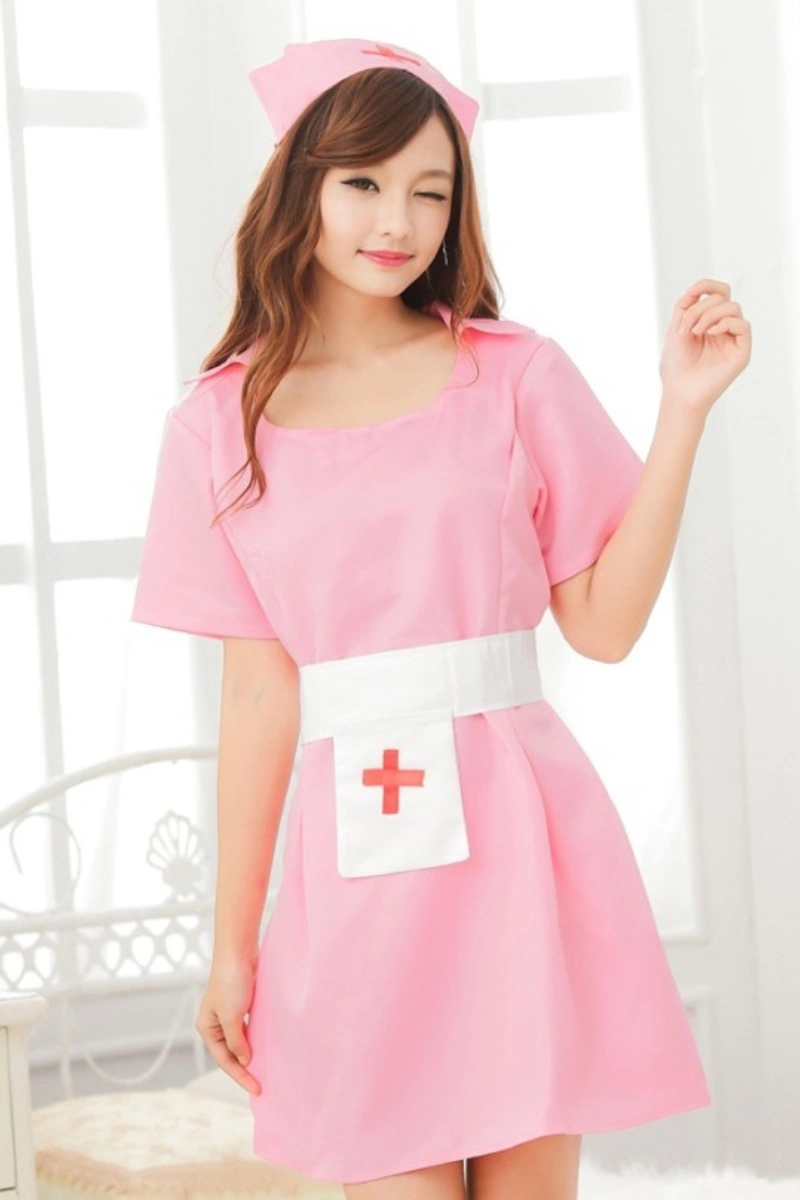 Model wearing a plus size sexy nurse outfit featuring a pink dress with white apron and matching nurse hat.