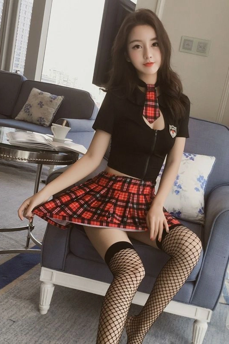 Front view of black JK cosplay costume with black fitted top, plaid tie, and pleated red skirt styled with fishnet stockings.