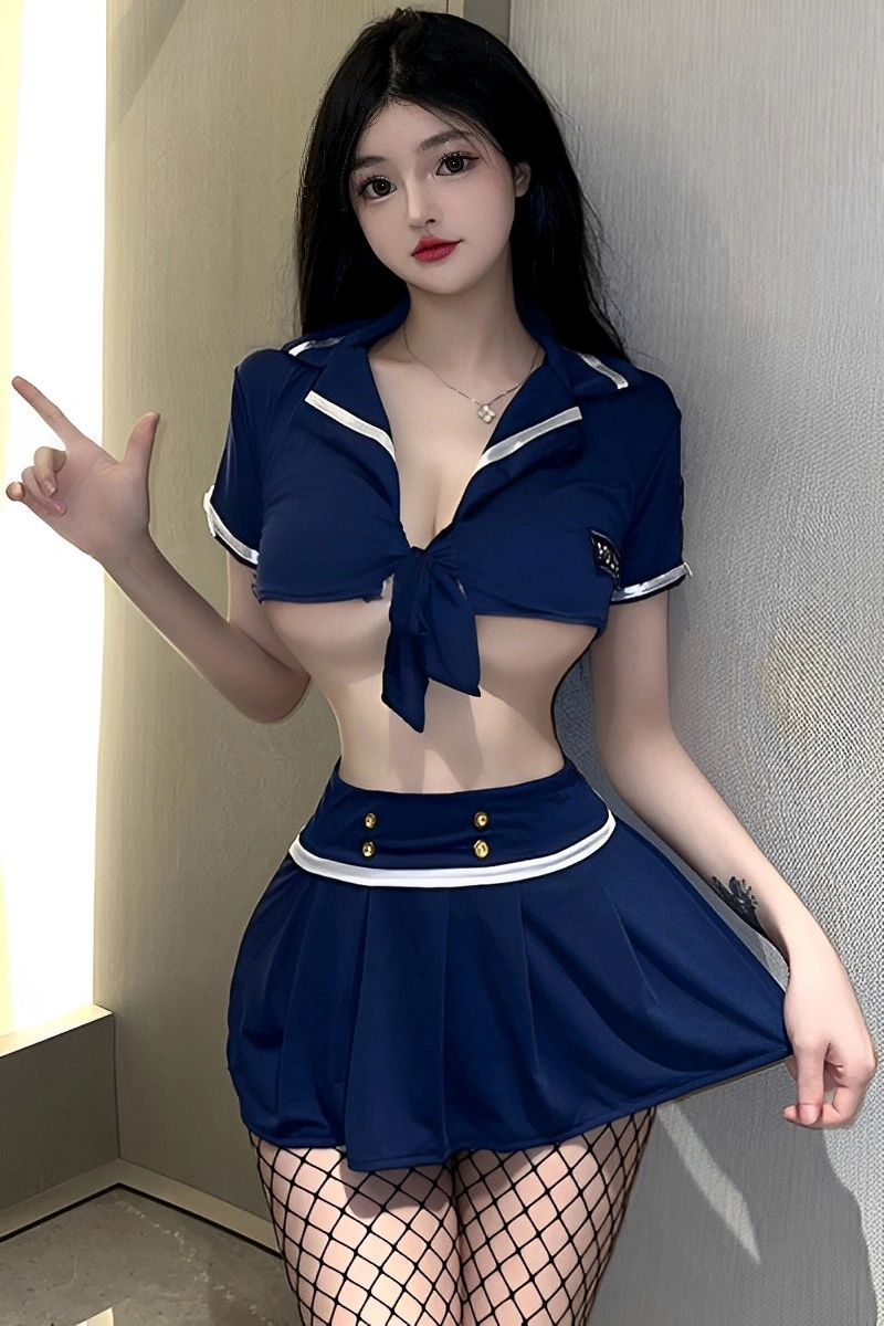 Model wearing a navy blue Policewoman Mini Dress with cropped tie-front top and pleated skirt, styled with fishnet stockings.
