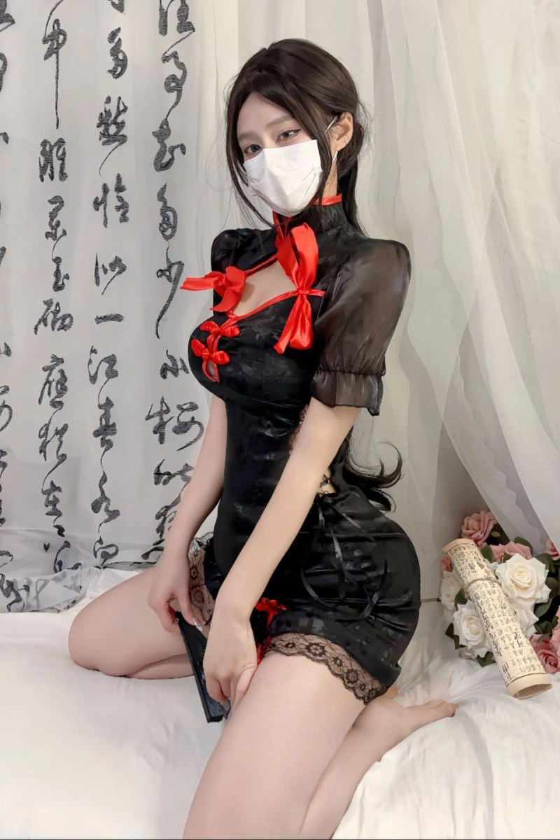 Model wearing black cheongsam cosplay lingerie with red satin bows and lace trim