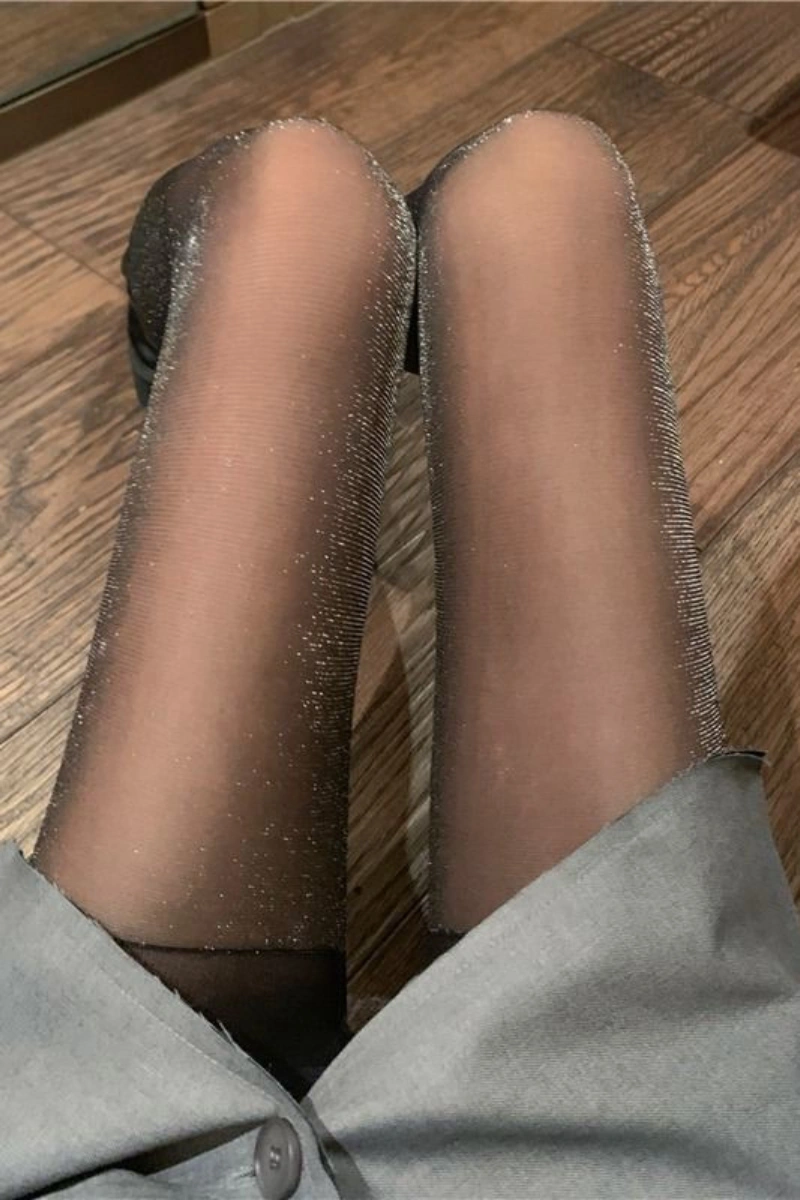 Close-up of silk stockings luxury gift with shimmering fabric details on black sheer stockings.