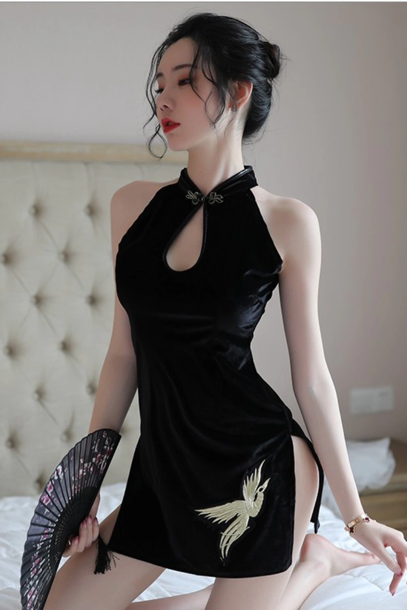 Model wearing vintage cheongsam lingerie in black velvet with golden bird embroidery, holding a fan.