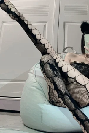 Sexy hollow patterned vintage silk stockings in black, styled with high heels for a bold retro look.