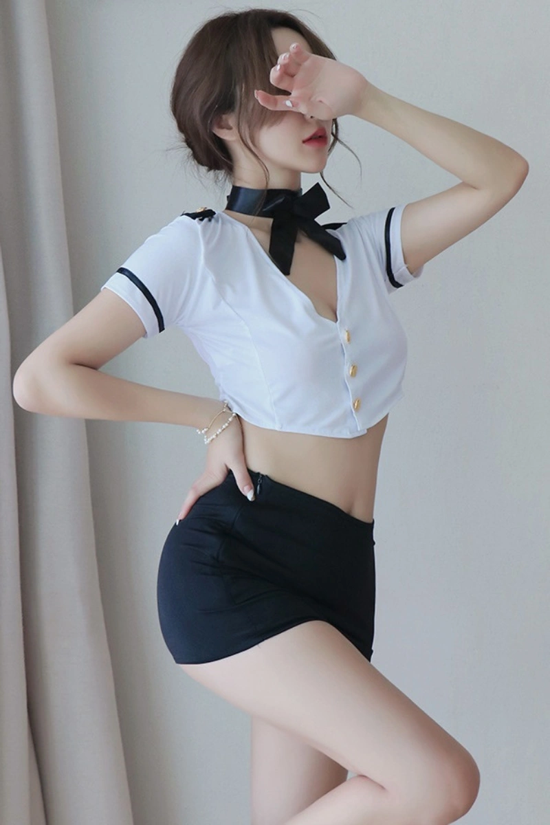 Model wearing wholesale sexy secretary costume featuring a white crop top with black bow and fitted black shorts.