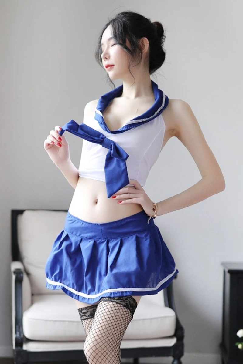 Model wearing wholesale student lingerie featuring a white crop top with blue sailor collar and a short pleated blue skirt.