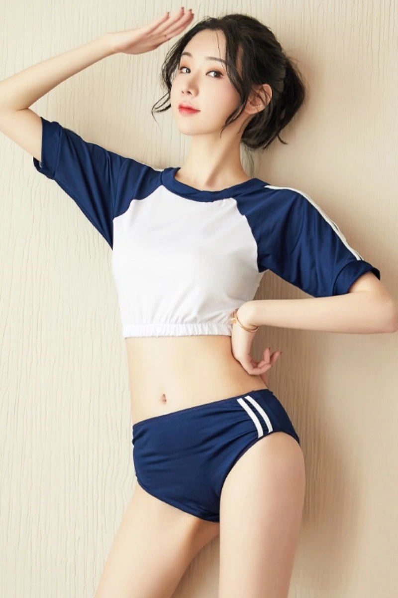Young woman posing in b2b cute student uniform with navy shorts and sporty crop top