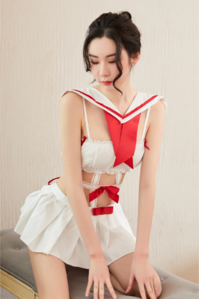 Model wearing a bulk student costume in white with red sailor collar and ribbon details