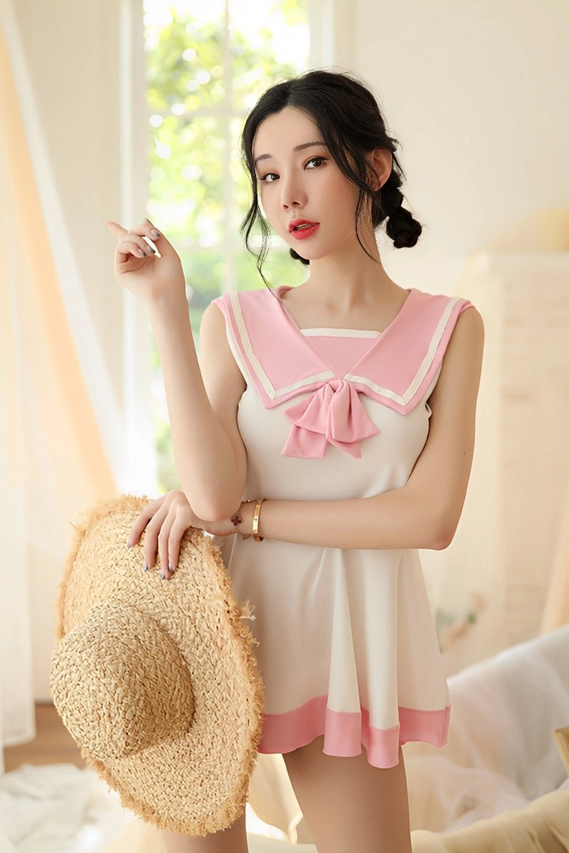 Model wearing wholesale cute student uniform with pink sailor collar and large bow, designed for B2B buyers.