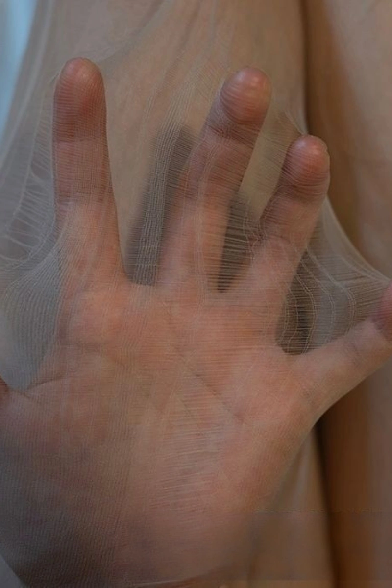 Close-up of wholesale silk stockings erotic ultra-thin sheer pantyhose stretched over hand.