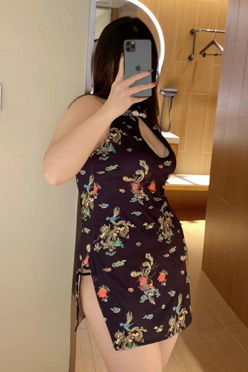 Plus size model posing in black floral cheongsam lingerie with golden dragon motifs