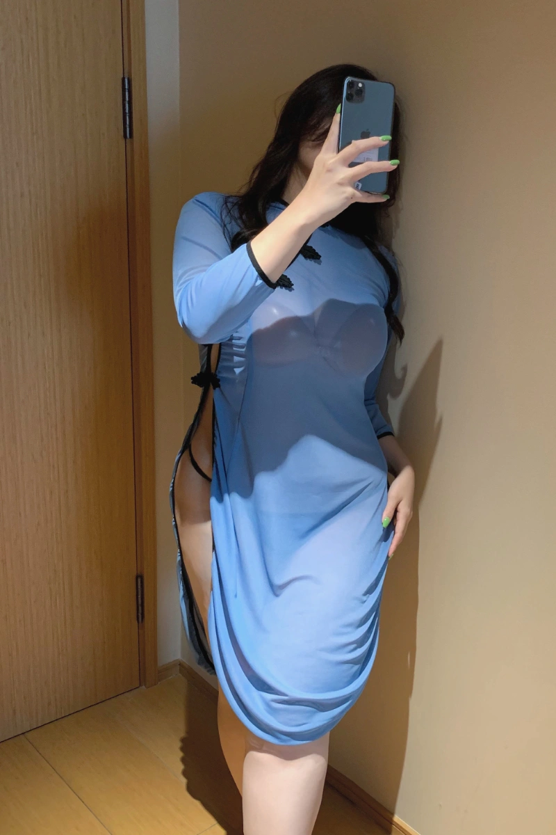 Model posing in sheer blue cheongsam lingerie with side slit and long sleeves