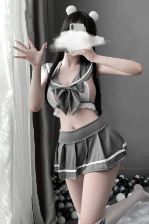 Female model dressed in wholesale JK student lingerie with gray sailor-inspired bow top and skirt.