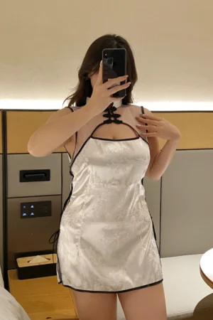 Sexy qipao lingerie in elegant white satin with black trim, featuring side ties and sheer neckline.