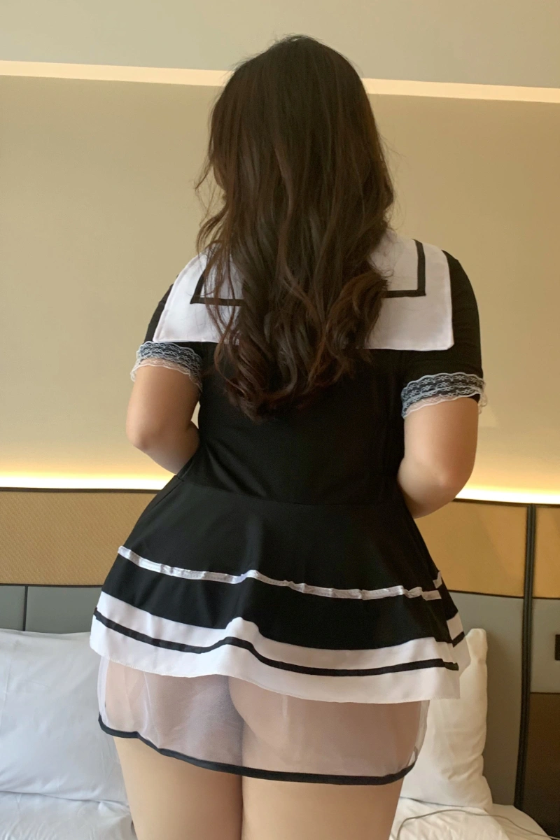 Back view of a student costume in black, featuring a sailor-style collar and lace sleeve trim.