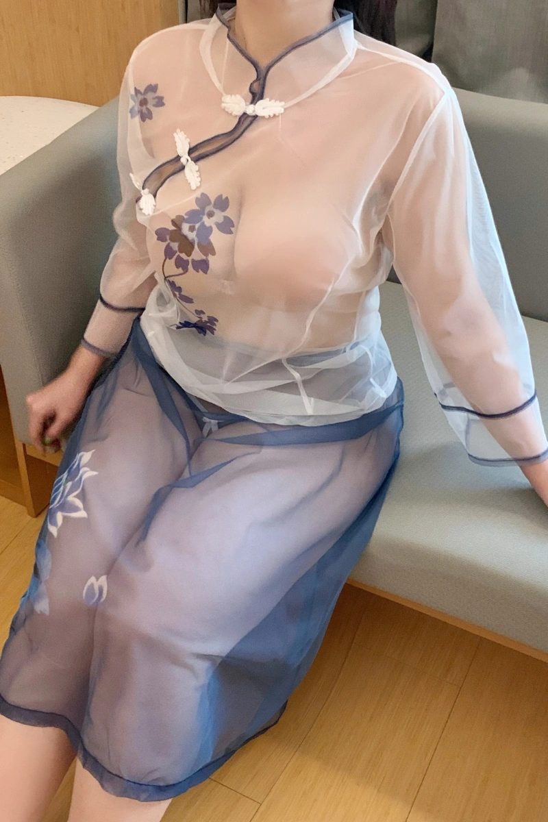 Model in white cheongsam lingerie with sheer mesh fabric and blue floral design.