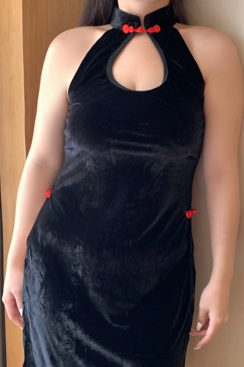 Model wearing wholesale plus size cheongsam lingerie in black velvet with red button details, featuring a halter neck and sexy keyhole cut.