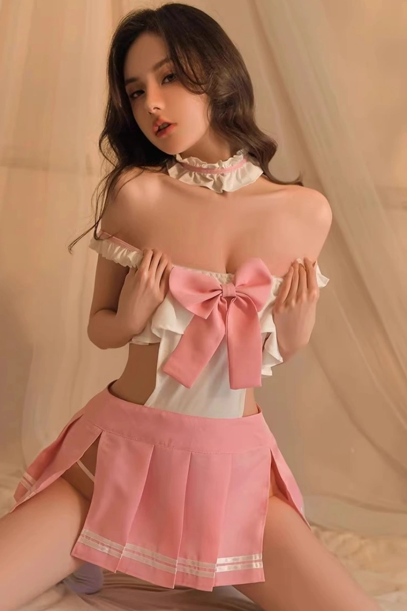 A model dressed in b2b JK sailor uniform lingerie with pink pleated skirt, ivory ruffle top, and oversized bow, tailored for B2B wholesale.