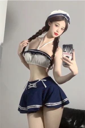 Model posing in b2b student lingerie with a white halter crop top and navy mini skirt, styled with playful braids