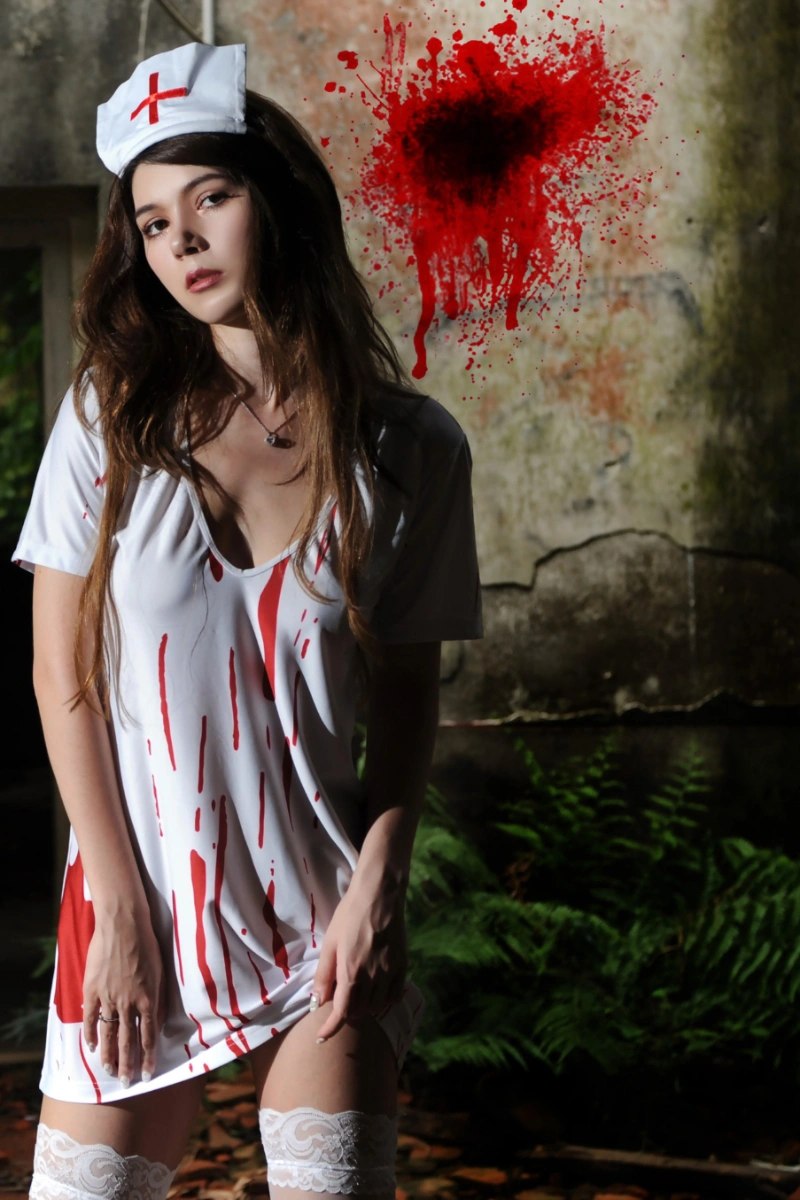 Model wearing a bloody nurse costume featuring a short white dress with red blood splatter and matching nurse cap.