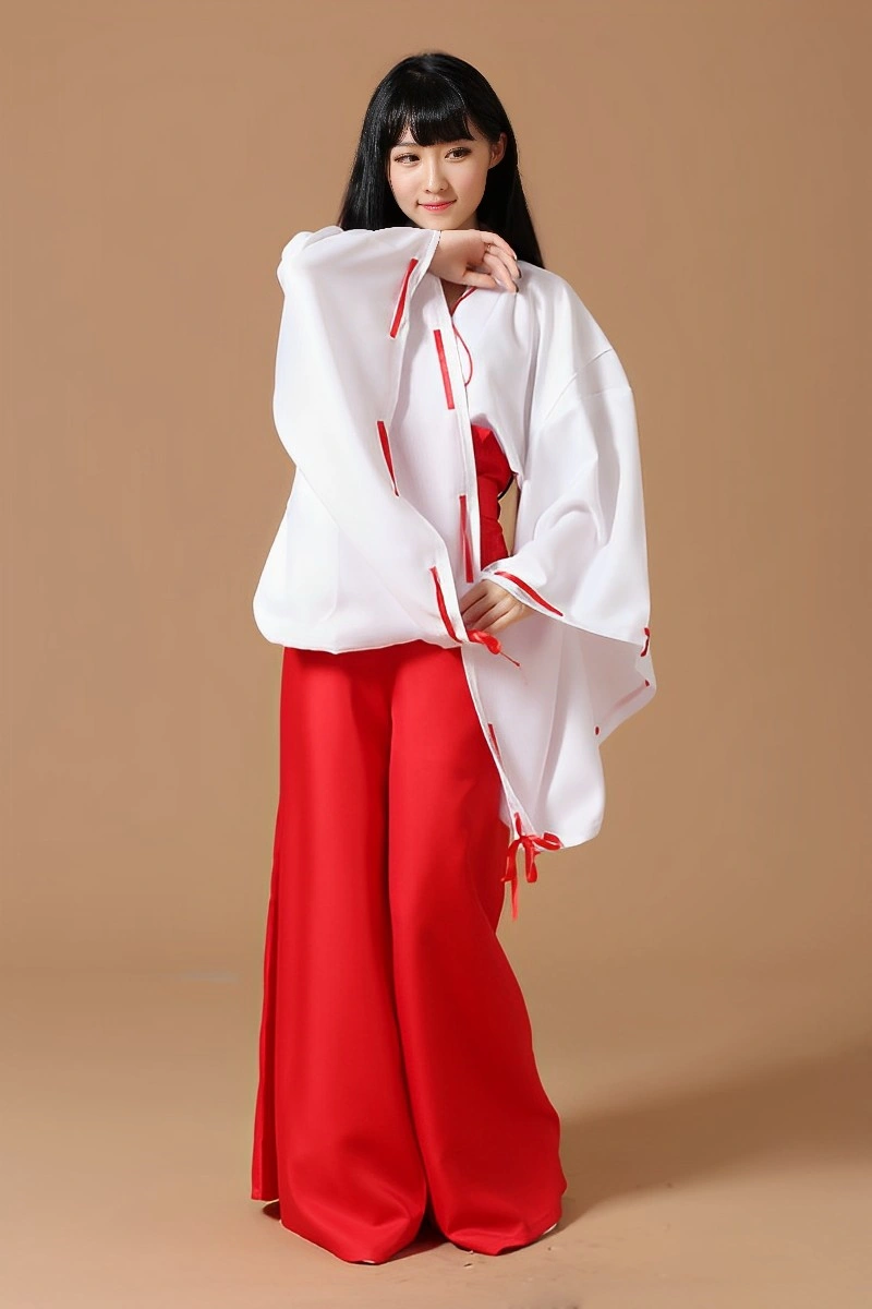 Model posing in Japanese Shrine Maiden Costume with wide sleeves, red hakama, and a white kimono top.