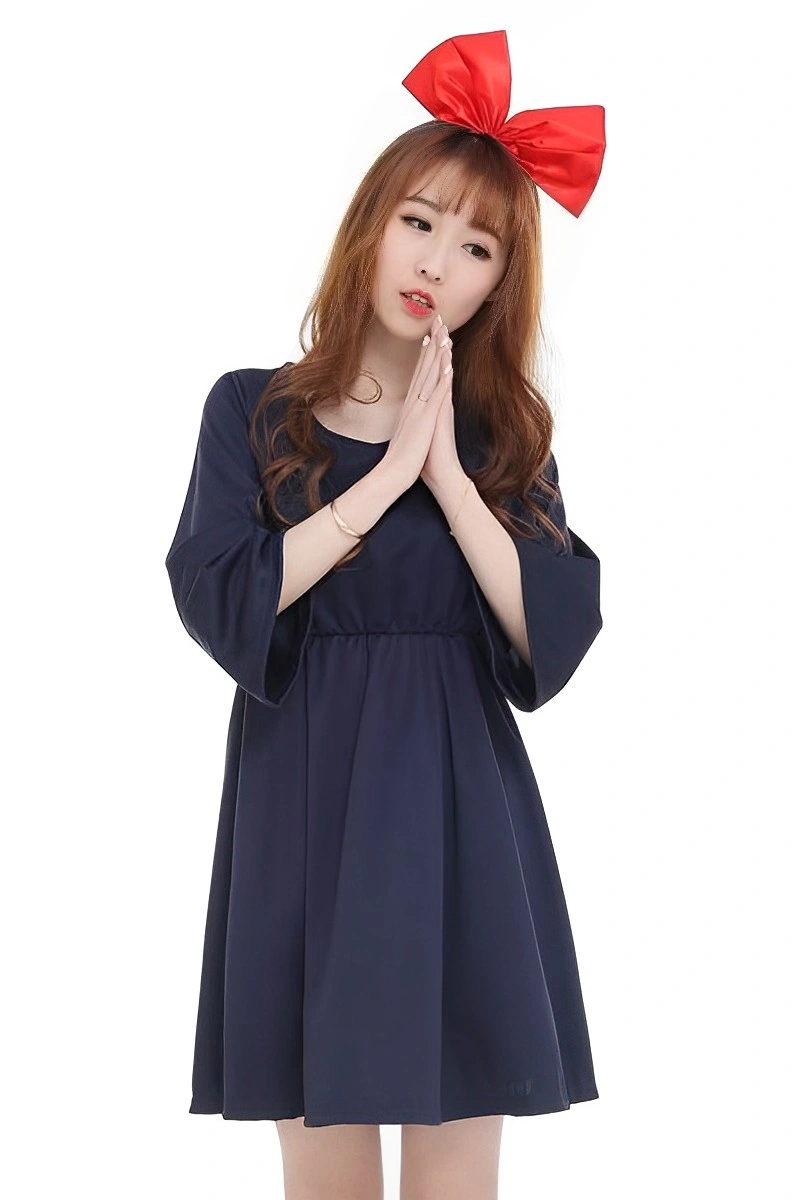 Model posing in navy school girl costume with long sleeves and red bow headband