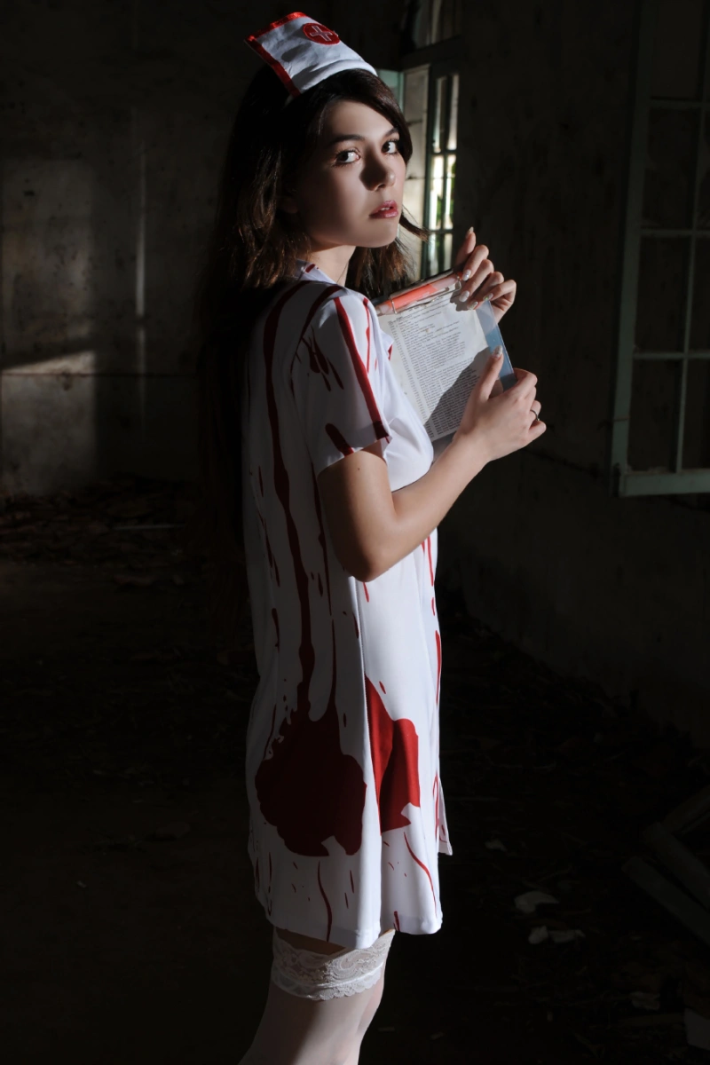 Model in Zombie Nurse Outfit holding a clipboard, featuring red bloodstain patterns.