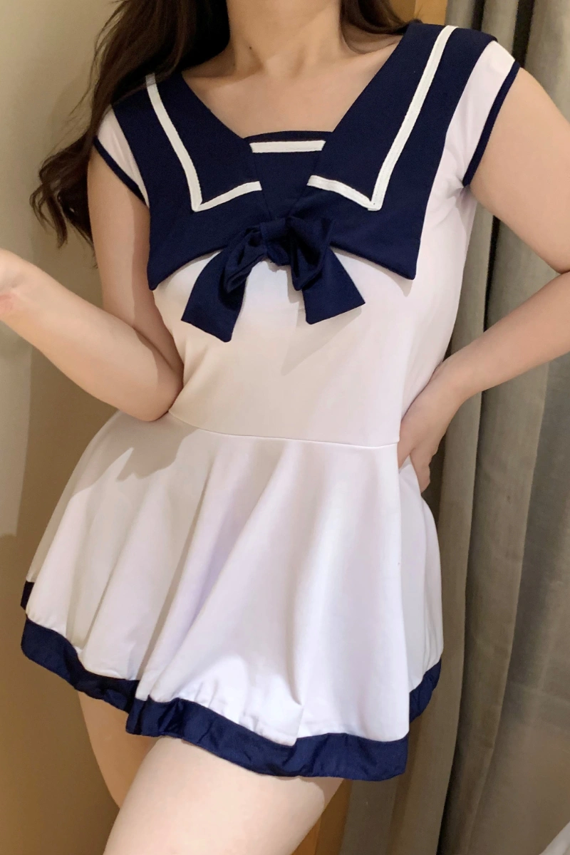 A sexy schoolgirl costume in white with navy blue sailor collar and bow, featuring a short pleated skirt design.