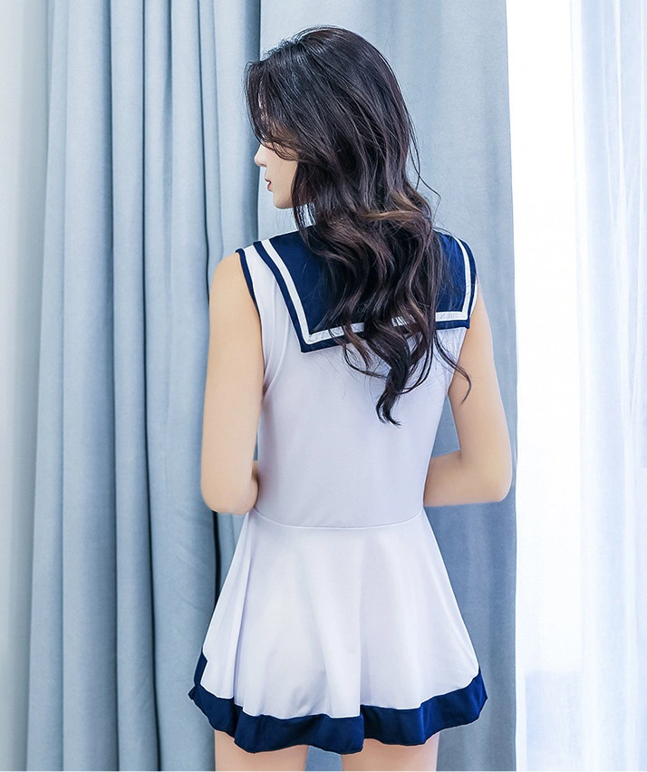 Back view of seductive student lingerie in sleeveless white dress with navy sailor collar and flowing hem.