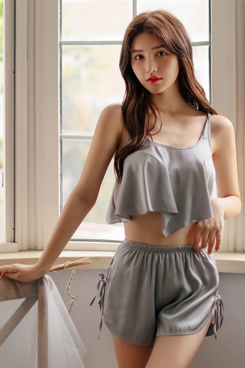 Alt Text:Model posing in sleek gray lace up pajamas