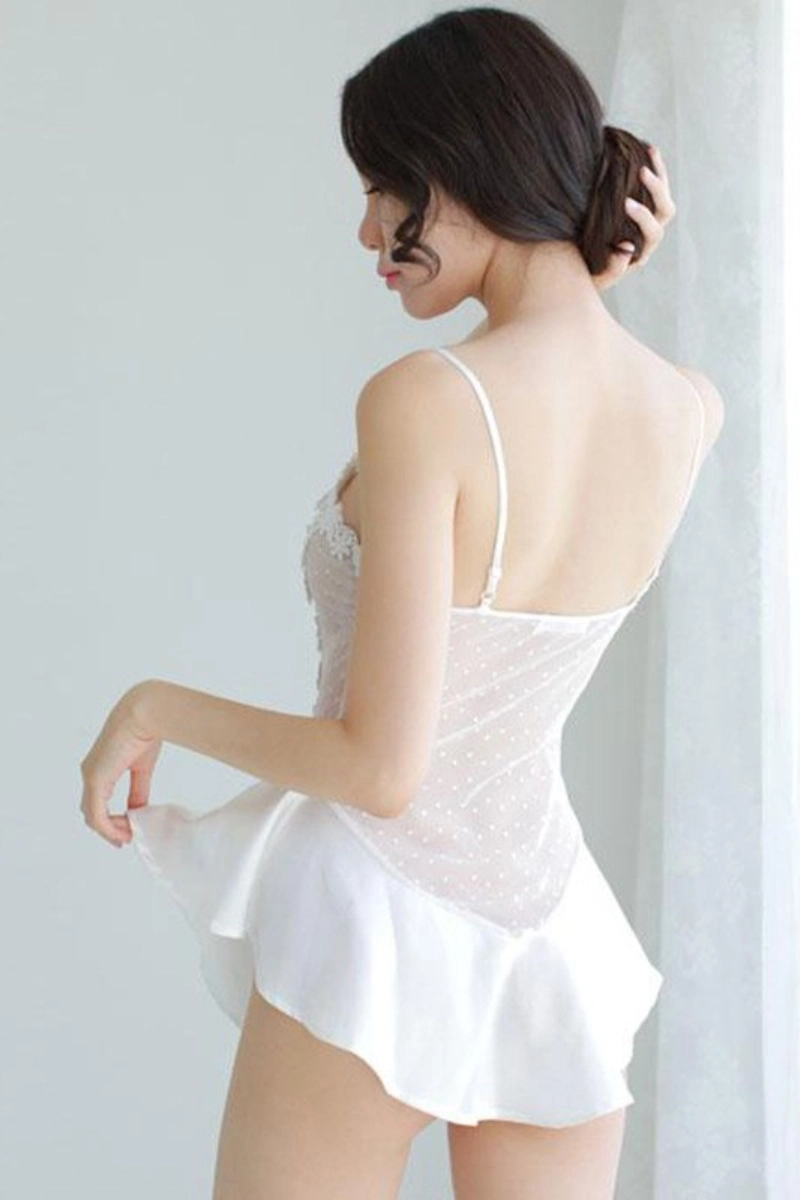 Back view of woman in white historical Victorian lace pajamas with polka dots