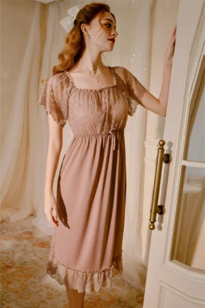 Model wearing soft taupe b2b lace bridal pajamas with sheer lace sleeves and flowing midi-length design
