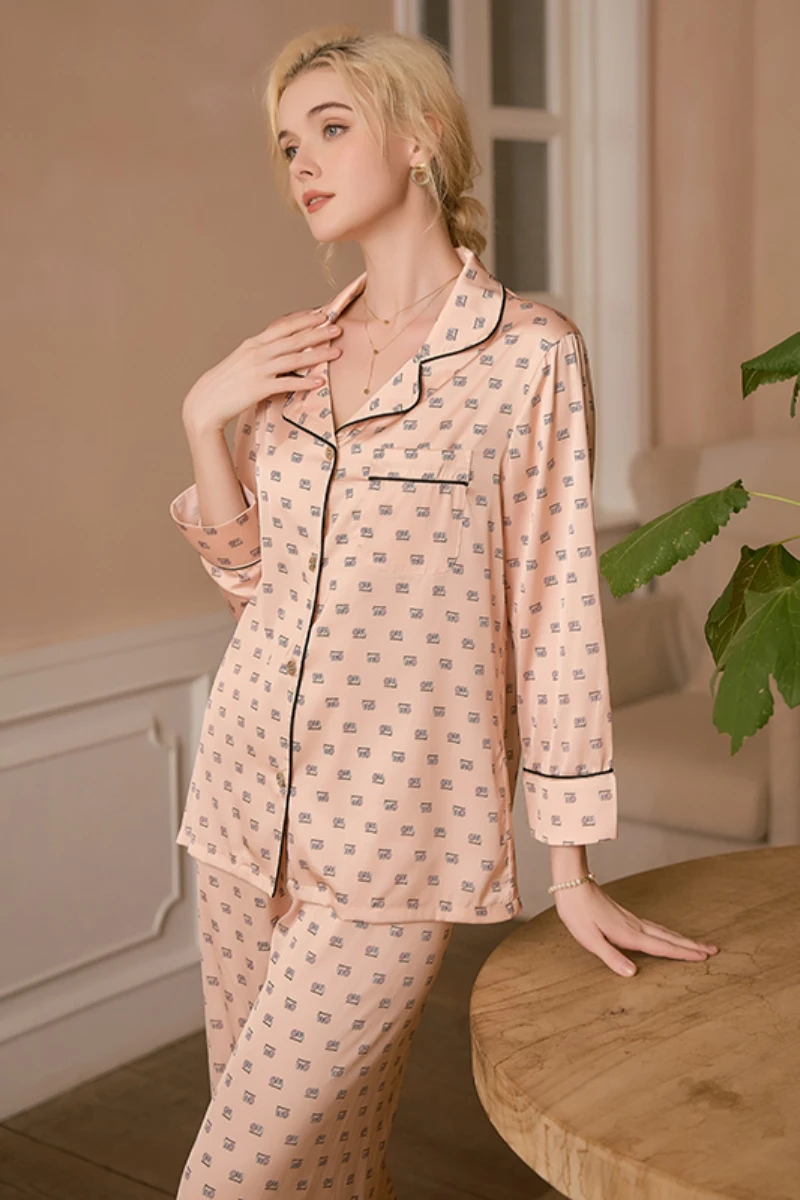 Front view of model wearing a b2b women's light pink sexy nightgown pajama set with button front top, long sleeves, and matching pants in a soft pink tone.