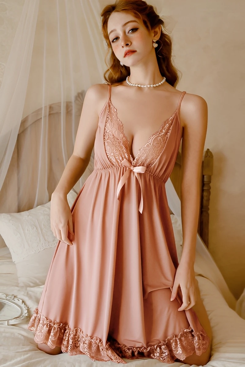 Blush pink silk pajamas with lace featuring a deep V neckline, lace trim, and flowing skirt hem.
