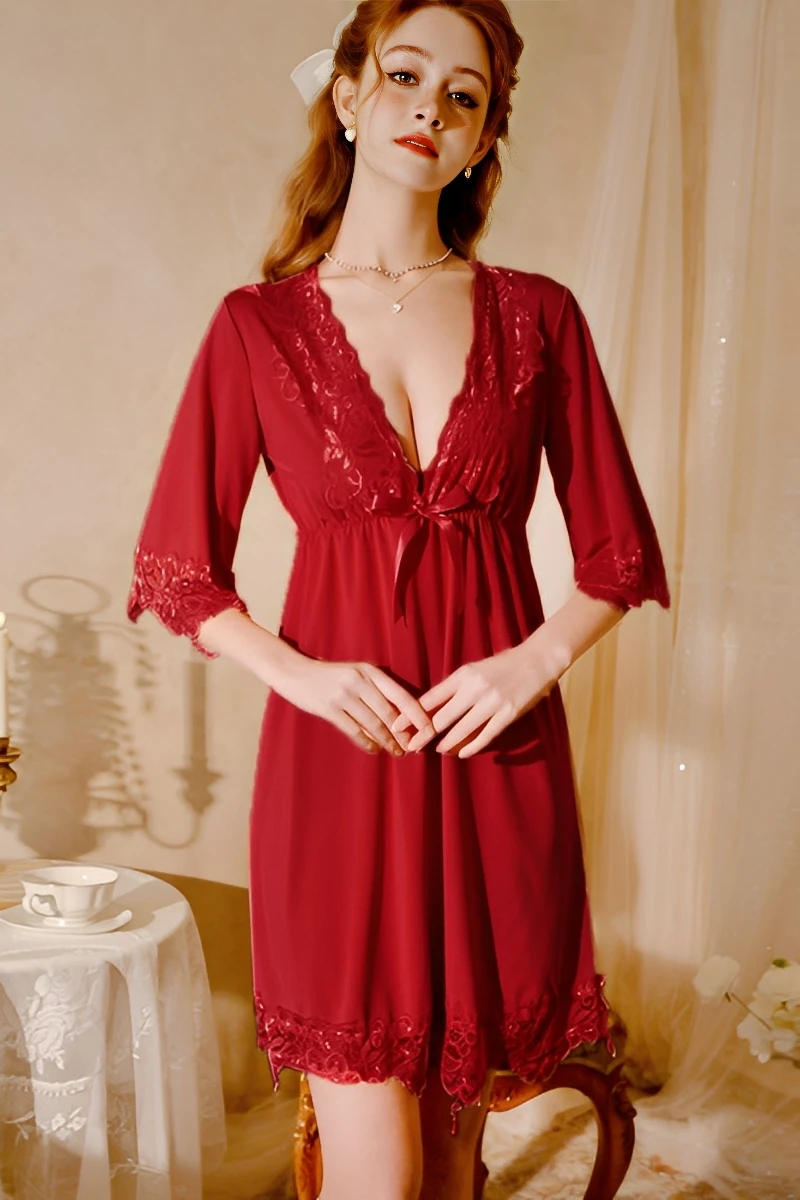 Model wearing a wine red bulk lace pajama with plunging V-neck, lace panels, and soft flowing skirt