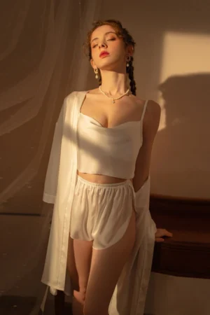 Model wearing white satin bulk Sexy Nightgown for Honeymoon with cropped cami top, shorts, and matching robe