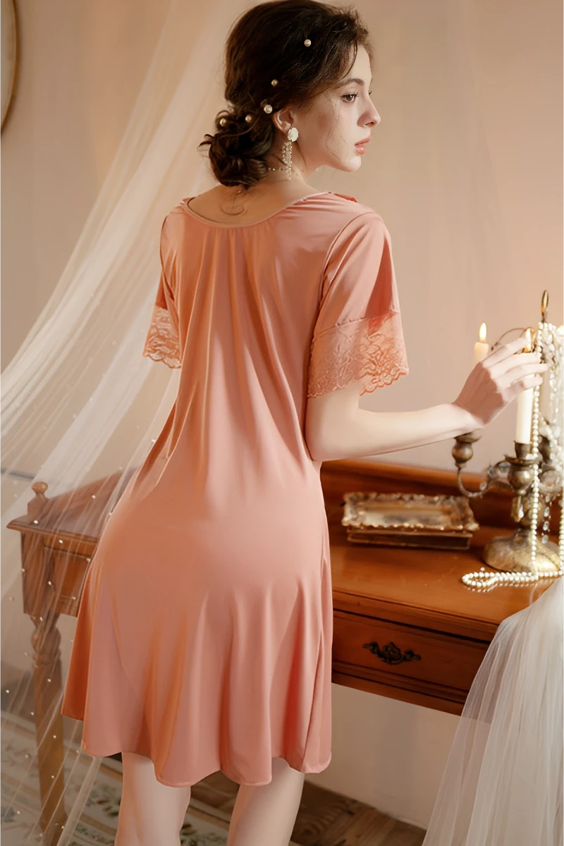 Back view of bulk women's sexy solid color lace pajamas in pink showing smooth fabric flow and lace sleeve edging.