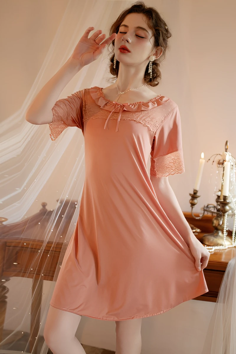 Model wearing bulk women's sexy solid color lace pajamas in soft pink with lace trim neckline and flowing short sleeves.