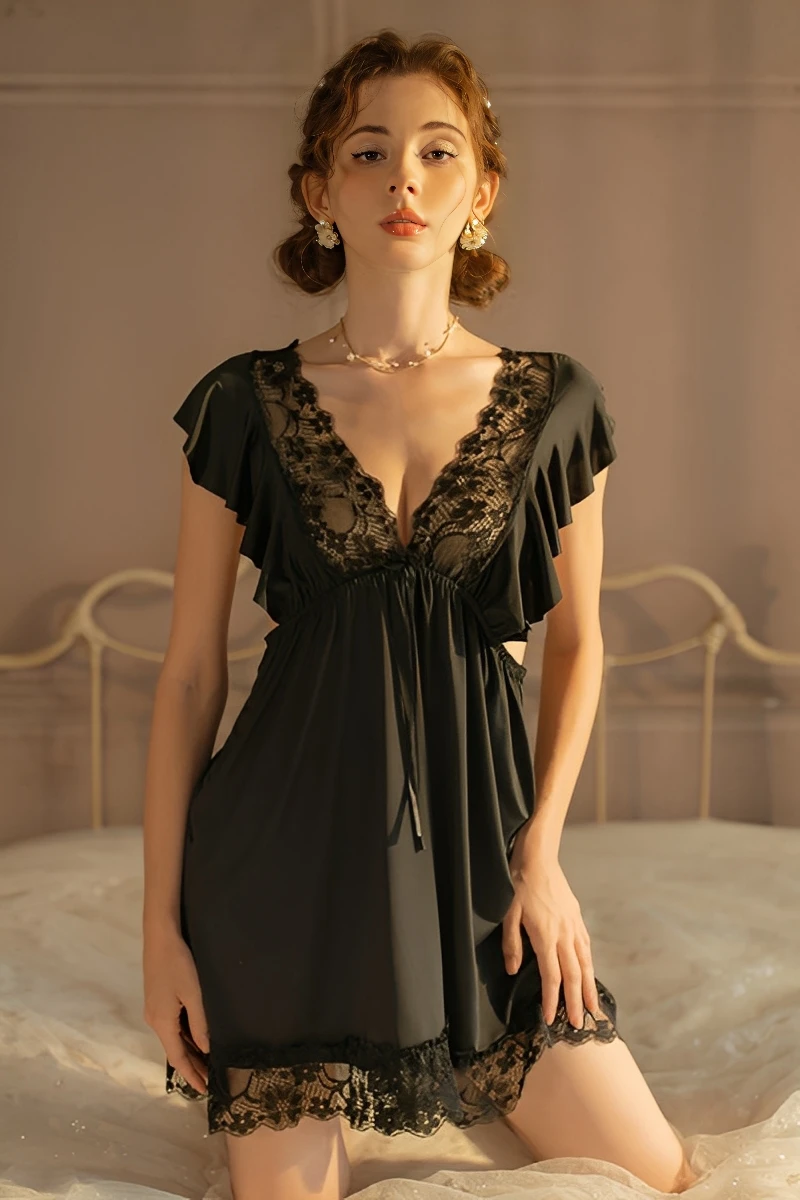 A classic black wholesale cute lace pajama set featuring a wide lace-trimmed neckline and a matching lace hem, modeled in a warm indoor setting.