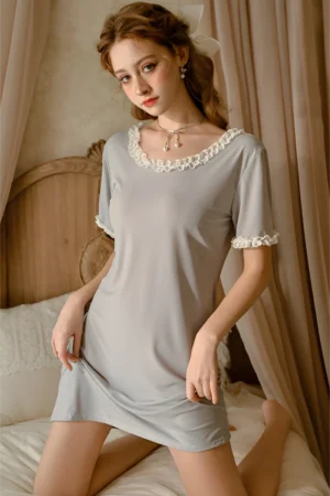 Model wearing a grey short sleeve pajama dress with lace neckline and cuffs, showcasing a custom lace pajama set for B2B buyers