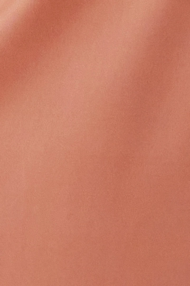 Close-up view of nude silk-like fabric texture, shown as part of a custom silk lace pajama set for B2B manufacturing